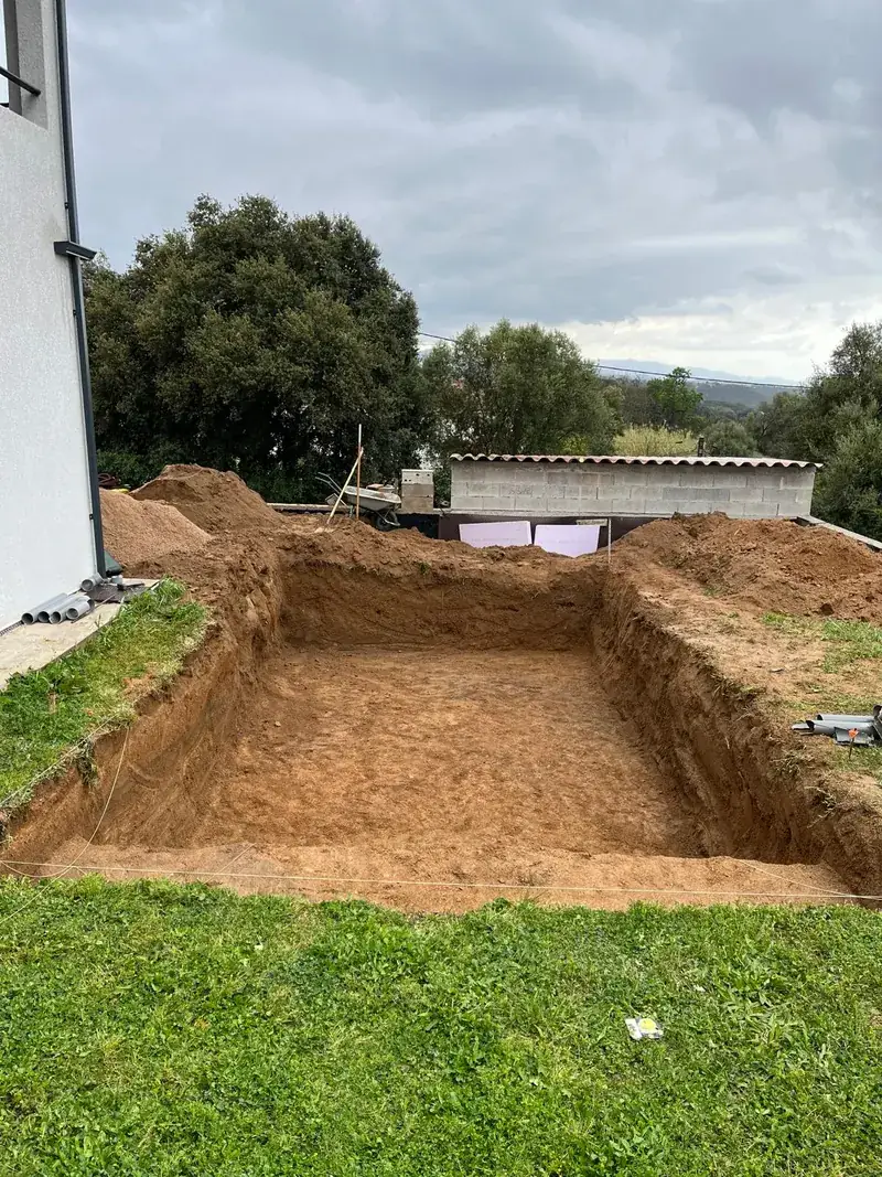 Trou de piscine rectangulaire creusé dans un jardin engazonné