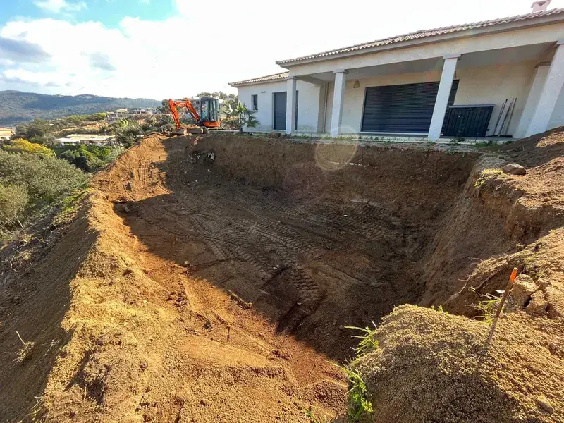 Fouille de piscine creusée devant une villa dans la région d'Ajaccio, mini-pelle en arrière-plan